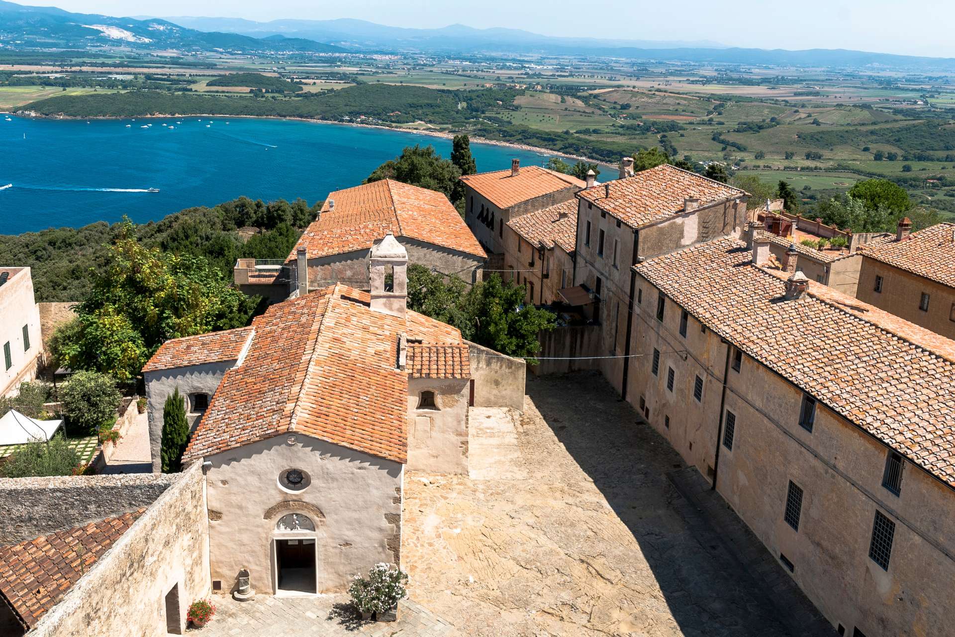 Piazza di Populonia con la chiesa e il Golfo di Baratti sullo sfondo